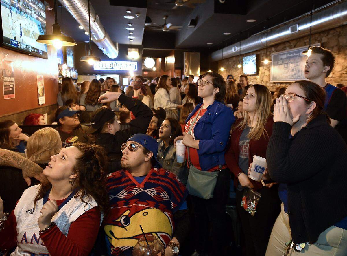 KU basketball fans watch the NCAA semifinal game at Quinton's Bar & Deli in Lawrence on Saturday, March 31, 2018. There were many disappointing moments for Jayhawk fans as Kansas fell to Villanova 95-79.