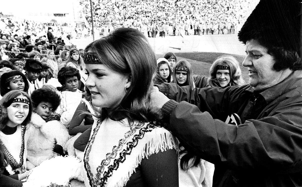 A member of the Kansas City Chiefs Chiefettes, left, has her outfitted adjusted before the start of a home football game at Arrowhead Stadium in 1970.