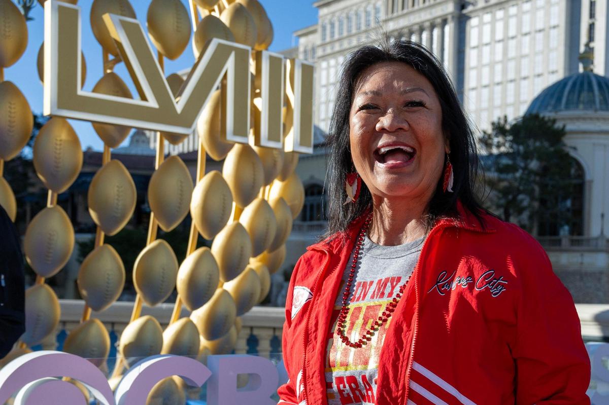 Bridie Stieren, a Kansas City Chiefs fan, smiles as she walks past a Super Bowl LVIII sign near the Bellagio Hotel and Casino on Saturday, Feb. 10, 2024, in Las Vegas.