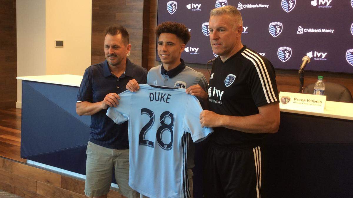 Cameron Duke (center), flanked by Sporting KC Academy director Jon Parry (left) and head coach Peter Vermes, signed a homegrown contract with the team.