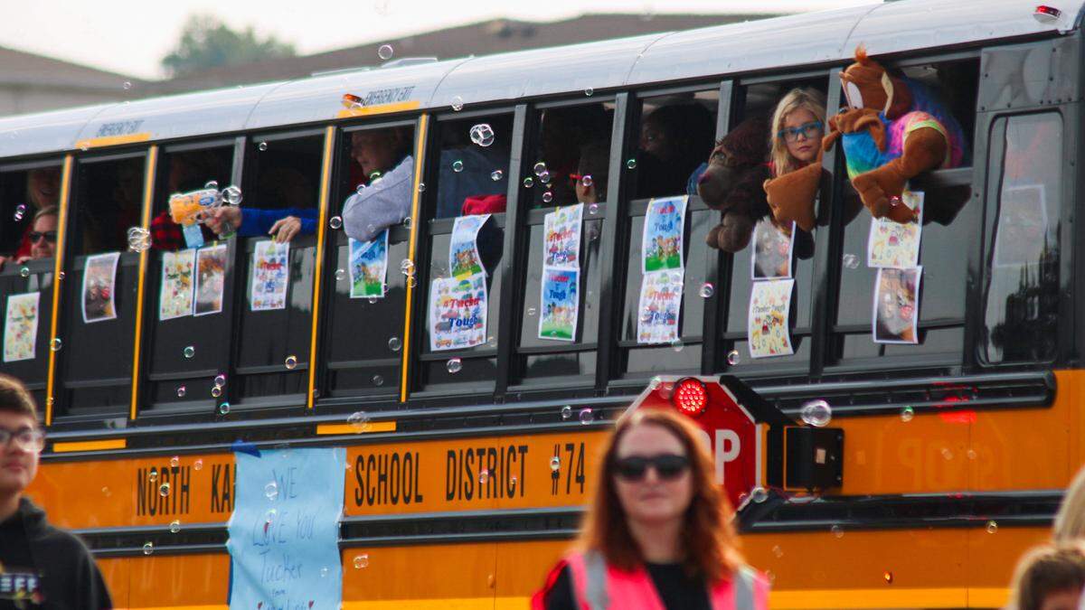 A group of students in a school bus participates in a parade for Tucker Langford, a 3-year-old battling terminal illness, on Saturday, Oct. 11, 2025.