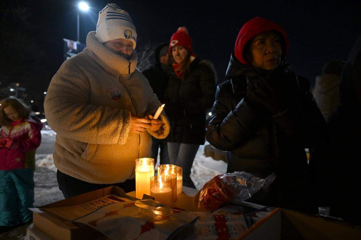 People gather items from a table during a candlelight vigil outside Research Medical Center to honor Alex Pretti on Thursday, Jan. 29, 2026, in Kansas City.