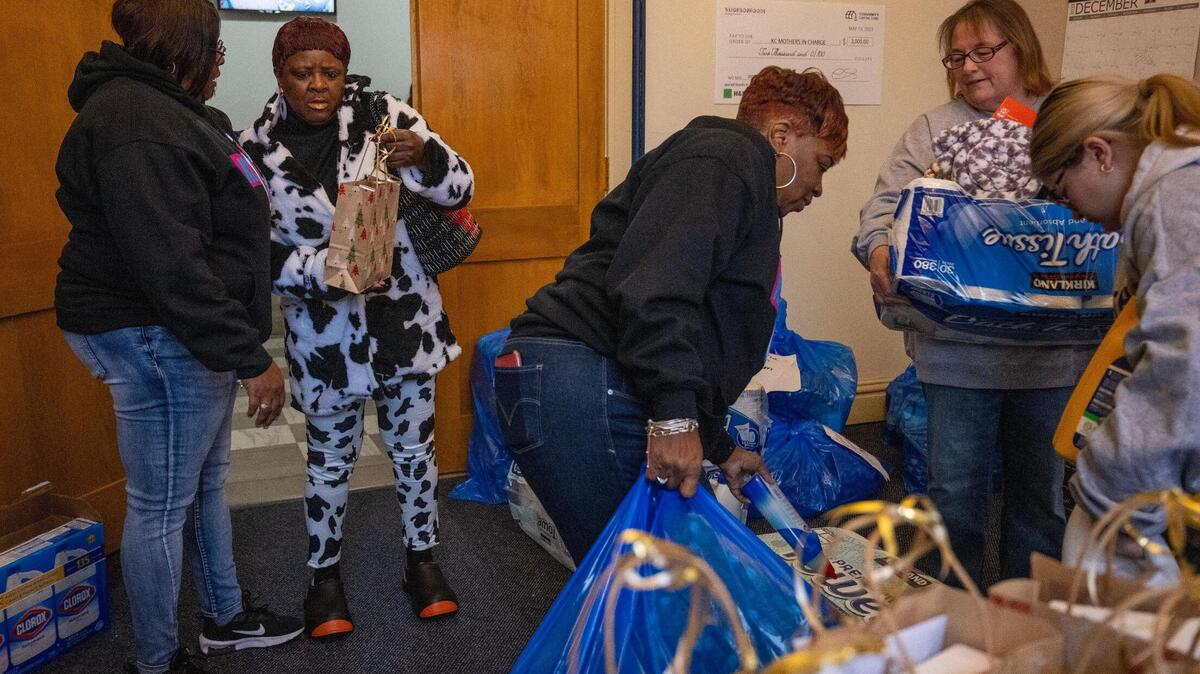 Angela Martin, center, receives assistance from volunteers with gifts she obtained during the Kansas City Mothers in Charge Christmas Giveaway event held at the Robert J. Mohart Multi-Purpose Center on Saturday, Dec. 16, 2023, in Kansas City.