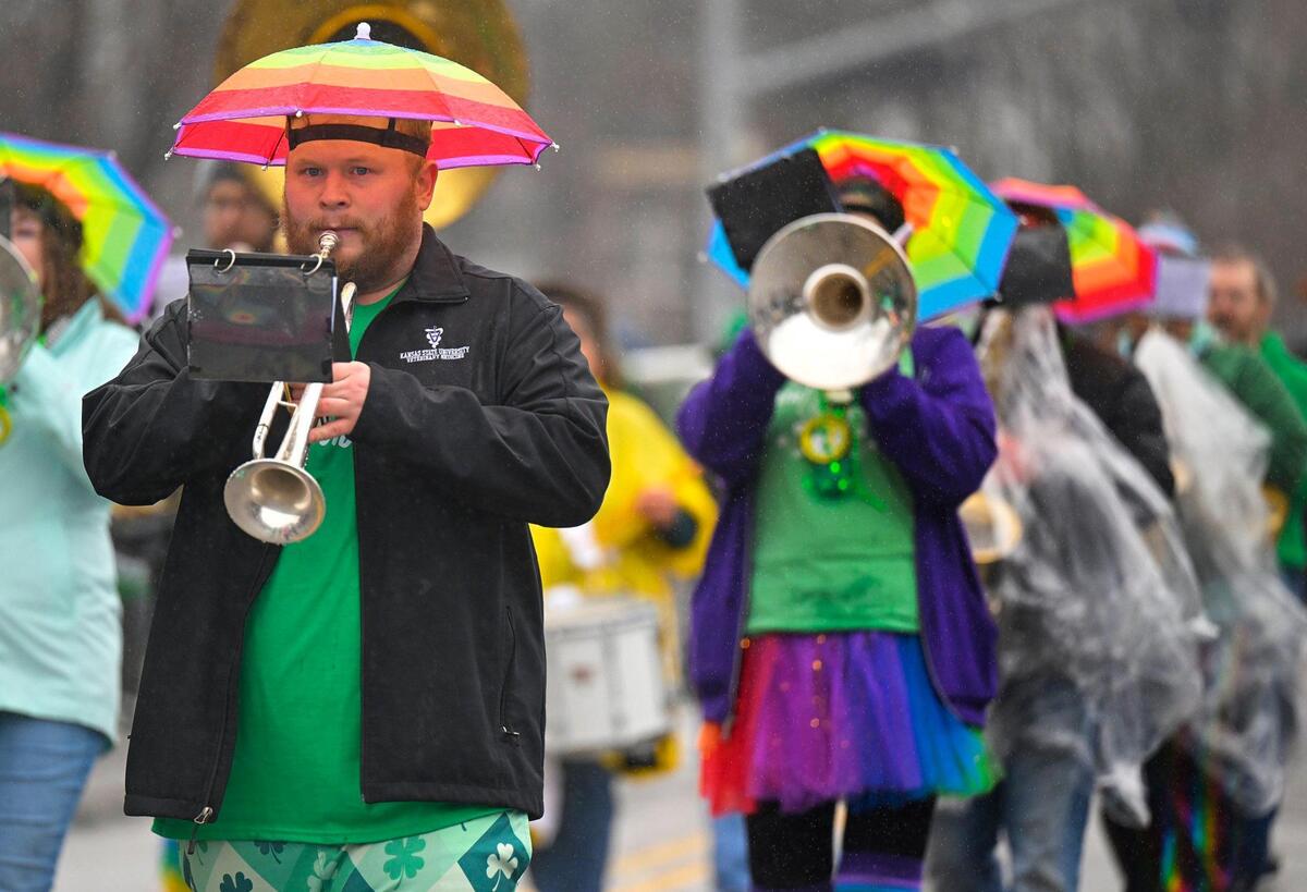 Members of the Mid America Freedom Band played as they marched in the rain during the 2023 Brookside St. Patrick’s Day Warm-Up Parade on Saturday March 11, 2023 in Kansas City.