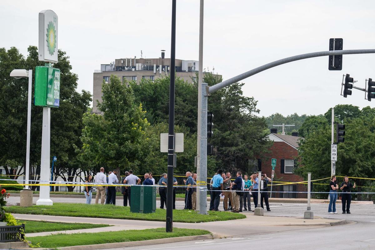 KCPD officers and officials stand near the scene of a KCPD officer involved shooting near Emmanuel Cleaver II Blvd and The Paseo on Thursday, July 24, 2025.