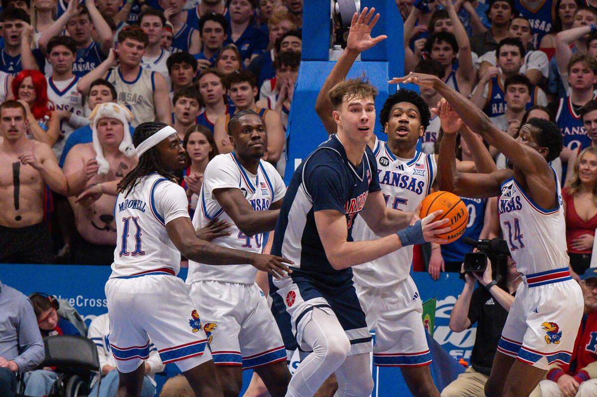 Kansas Jayhawks defenders surround Arizona Wildcats center Motiejus Krivas (13) in the first half on Monday, February 9, 2026, at Allen Fieldhouse.