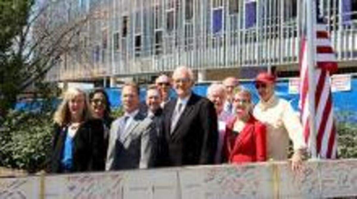 After putting their signatures on it, Johnson County officials posed with the white beam before it was hoisted to the highest point in the structural framing of the new courthouse.