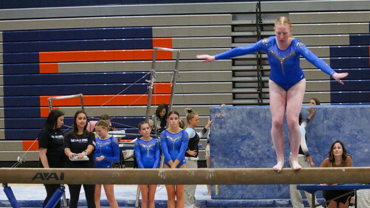 The Olathe South High School gymnastics team watches as a teammate competes in the state meet on Oct. 25, 2025.