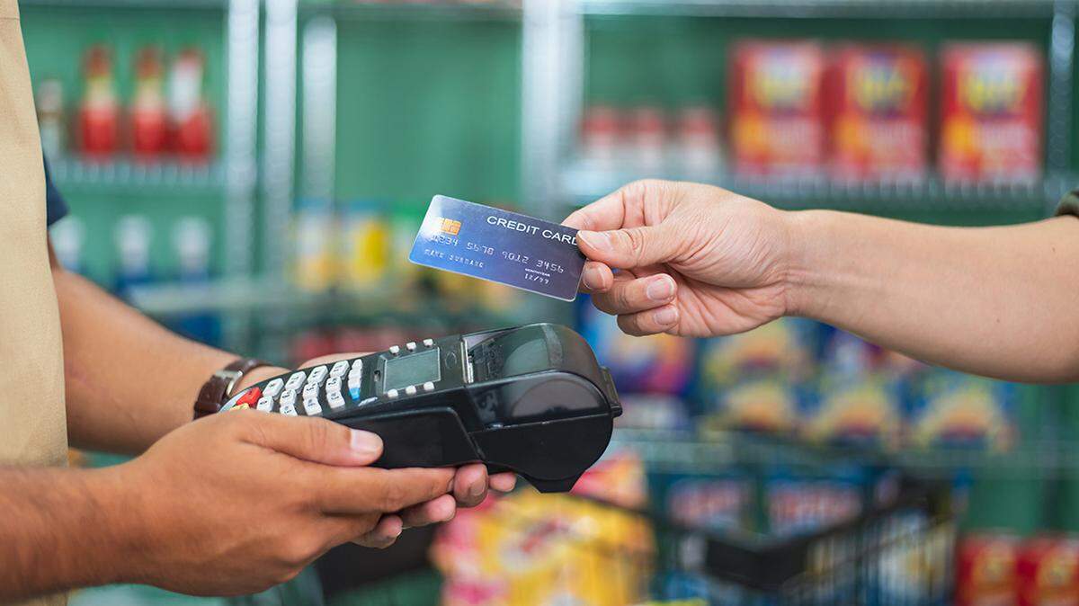 Customer using credit card for payment to owner at cafe restaurant, cashless technology and credit card payment concept swipe pay