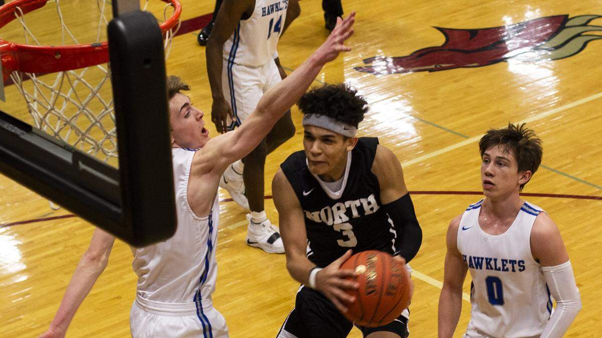 Senior guard Javaunte Hawkins of Lee’s Summit North splits the Rockhurst defense Friday night in the Class 5 District 13 championship game at Lee’s Summit North. The LSN Broncos claimed the title 61-48 after trailing 11-0 in the first quarter.