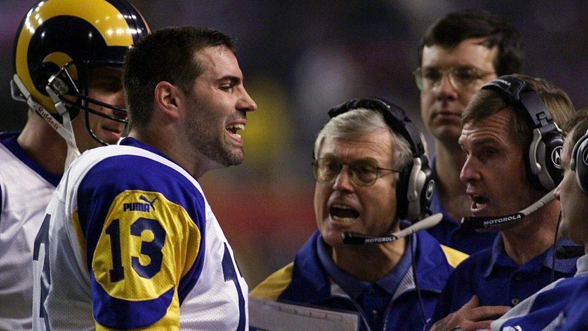 This Jan. 30, 2000, photo shows St. Louis Rams quarterback Kurt Warner talking to Rams head coach Dick Vermeil, at center, and other coaches during a St. Louis Rams timeout in the second quarter in Super Bowl XXXIV in Atlanta.