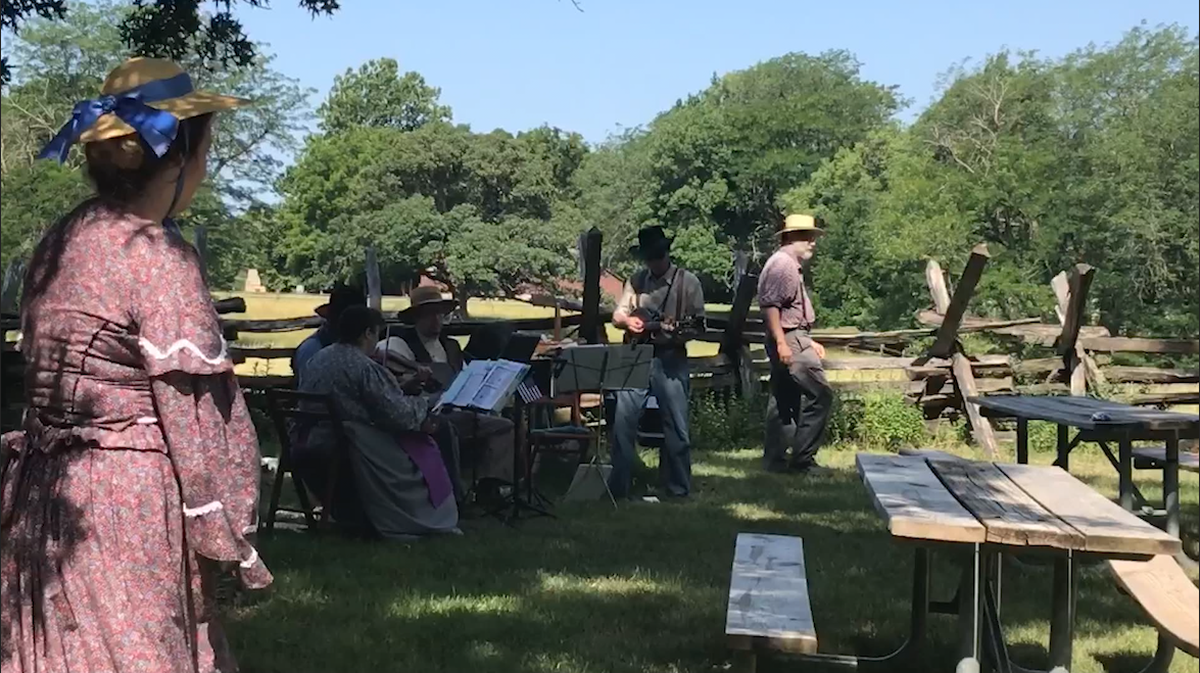 Interpreters dressed in period clothes from 1855 played folk music at Missouri Town's July 4th celebration near Blue Springs.