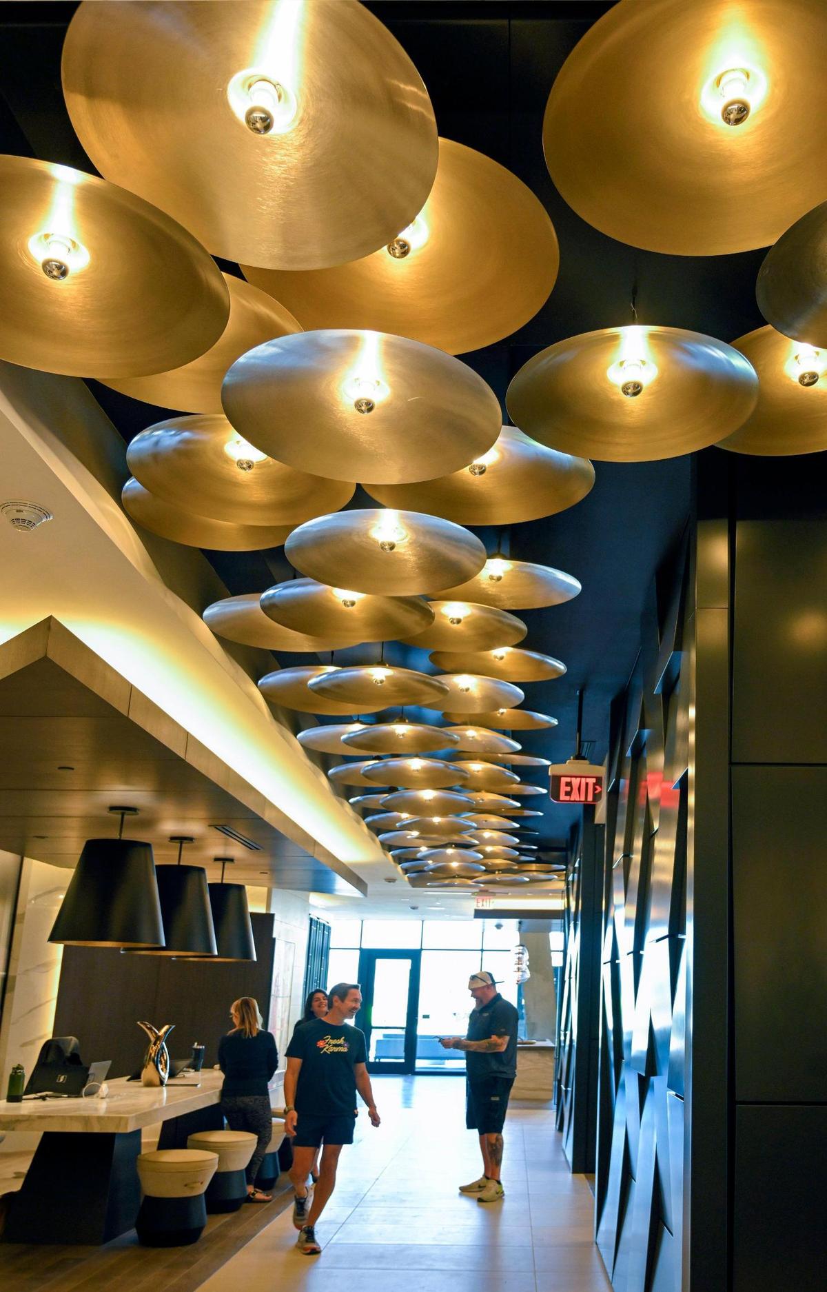 Brass cymbals, used as lighting, have been incorporated into the jazz-inspired decor at the new Three Light Luxury Apartments.