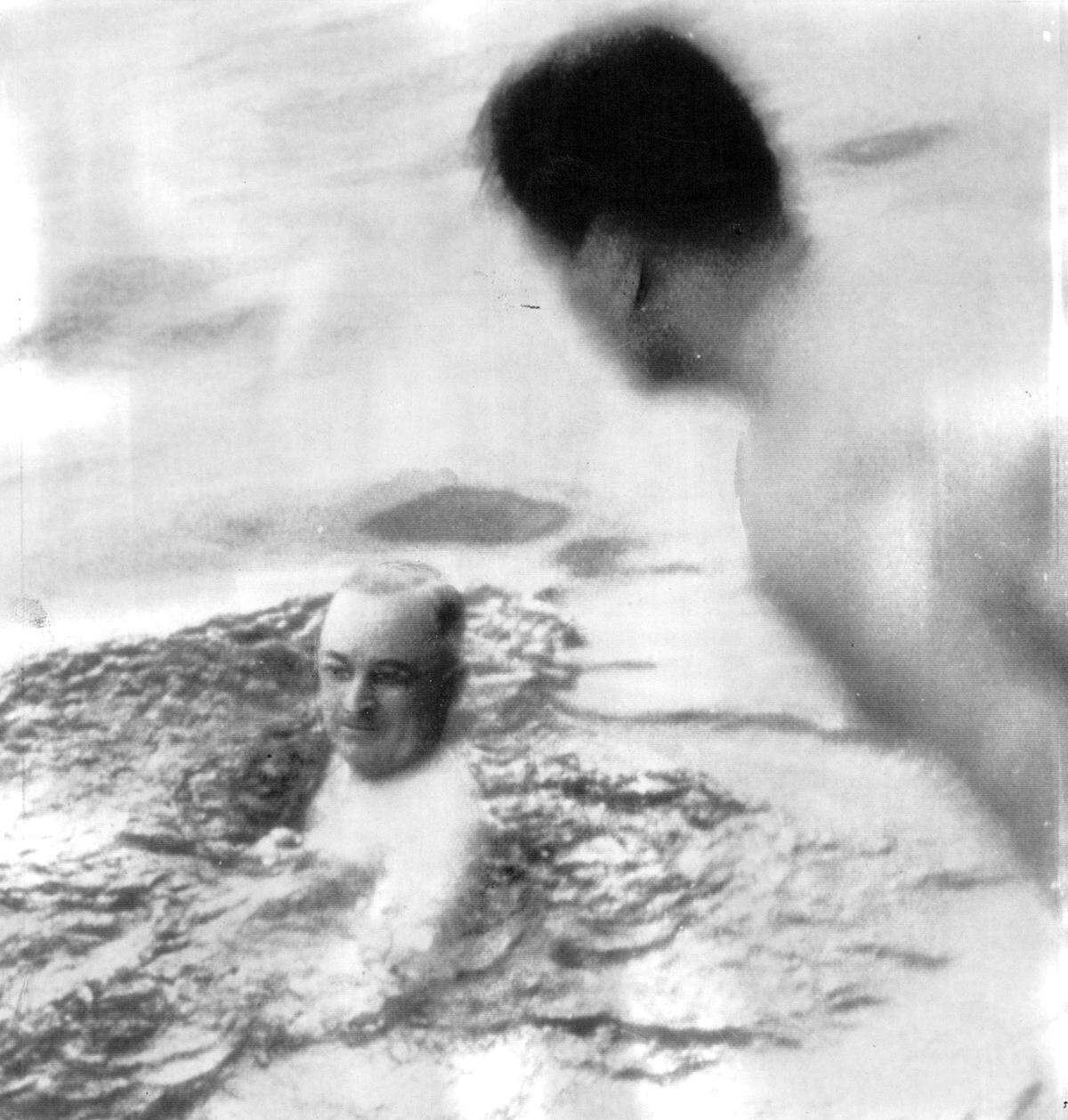 President Harry S. Truman swims off the side of a yacht in Delaware Bay during a 1946 vacation cruise. A member of his party stands ready to dive in and join him.