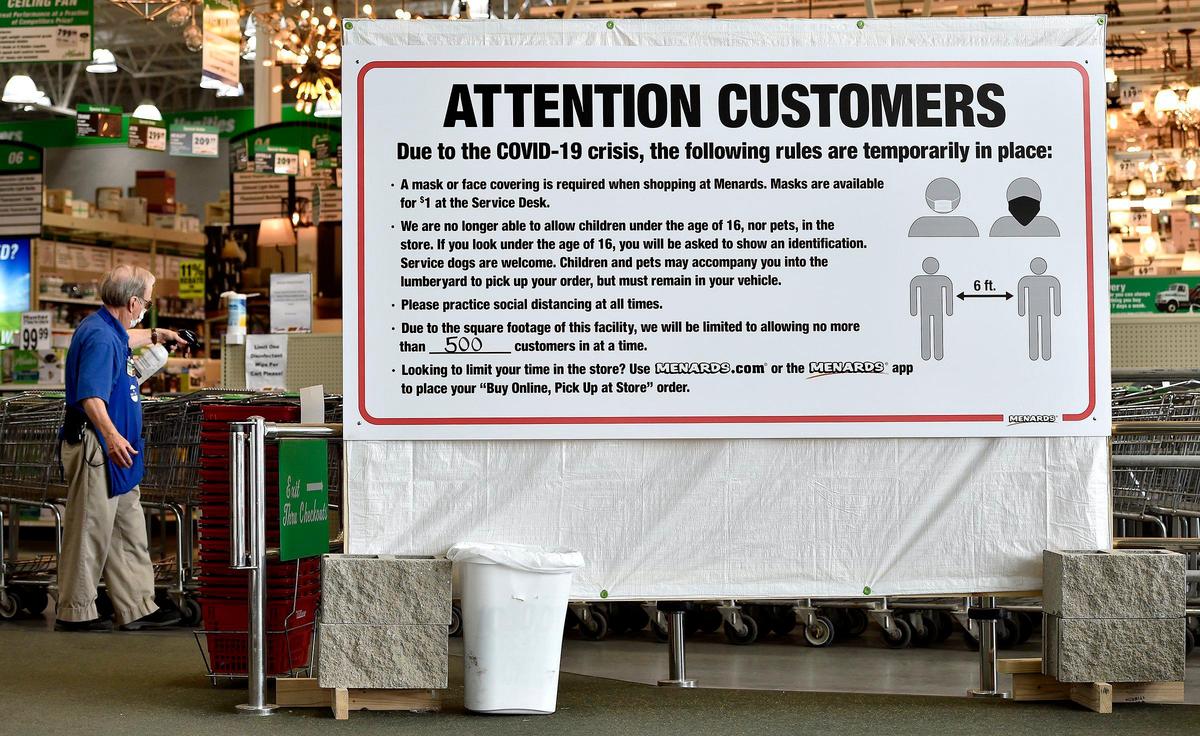 The Menards store in Kansas City, North has its COVID-19 policies posted on a large sign just inside the entrance. Customers are required to wear masks, and children and pets are not allowed inside. An employee sanitized shopping carts Wednesday.