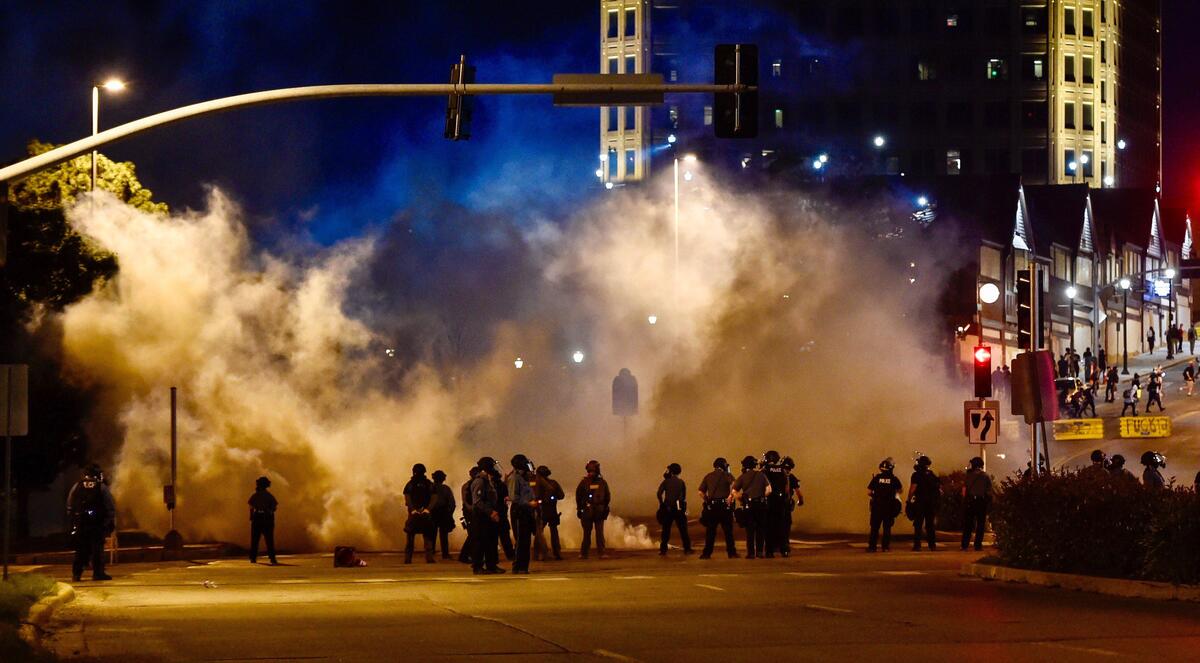 Law enforcement officers deploy tear gas on Main Street near the Country Club Plaza Monday to disperse protesters who continued to protest the death of George Floyd while in the custody of Minneapolis police.