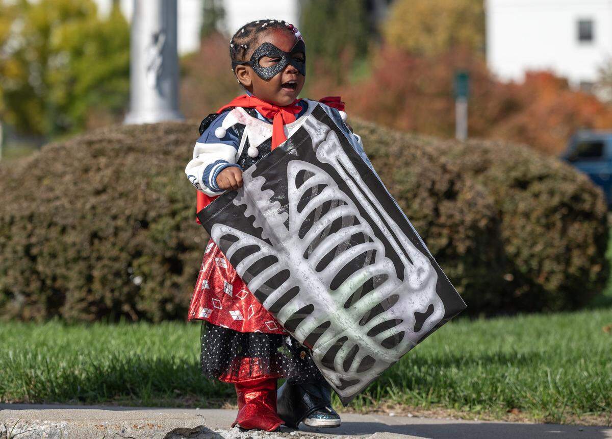 Two-year-old Penny Edwards walks with her large trick-or-treat bag while dressed in costume during Russell Stover's annual Halloween candy giveaway at the company's headquarters on Friday, Oct. 31, 2025, in Kansas City.