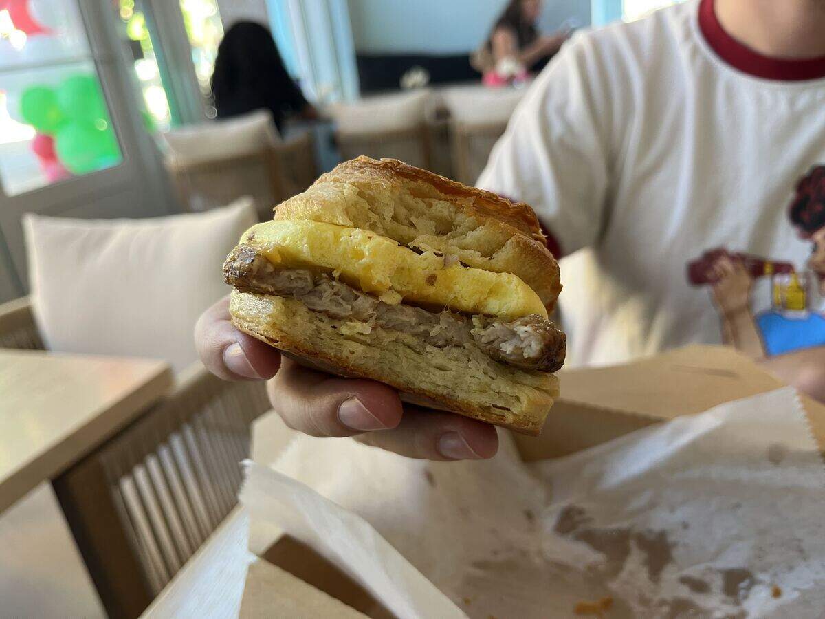 The Egg & Cheese Sandwich, made with a croissant bun and the choice of sausage or bacon for $8.
