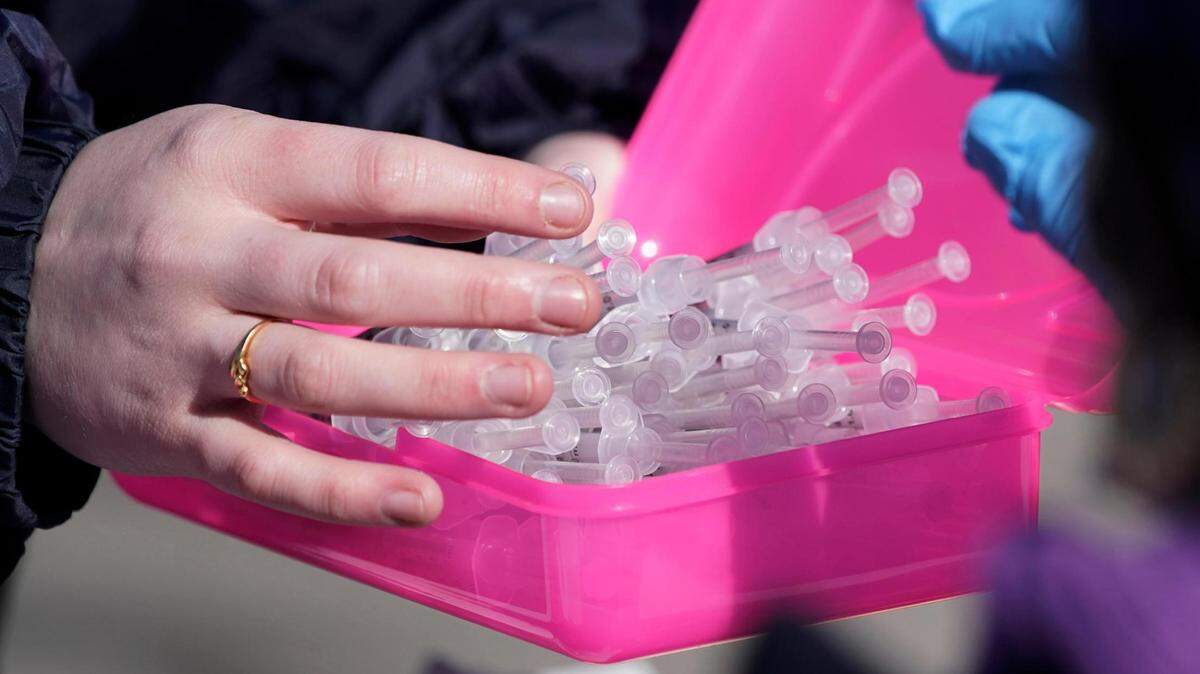 Filled syringes are taken to nurses to be injected at a COVID-19 mass vaccination site in Kansas City, Mo., Friday, March 19, 2021.