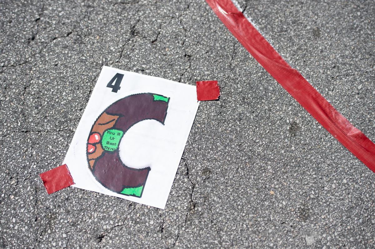 A small rendering of the letter “C” in the Black Lives Matter mural being painted on 63rd St. near Brookside Blvd. was taped on the pavement to help the painters understand the design.