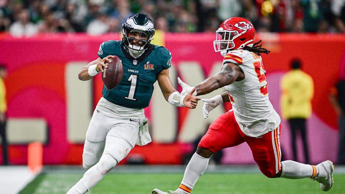 Philadelphia Eagles quarterback Jalen Hurts (1) scrambles past the defense of Kansas City Chiefs defensive end Mike Danna (51) in the fourth quarter during Super Bowl LIX on Sunday, Feb. 9, 2025, in New Orleans.