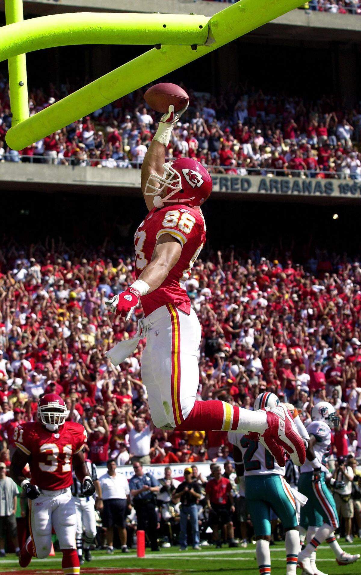 Kansas City Chiefs tight end Tony Gonzalez dunks the football over the goalpost after scoring a touchdown in the first quarter on Sept. 29, 2002, against the Miami Dolphins at Arrowhead Stadium. Gonzalez scored three touchdowns on the day against the Dolphins.