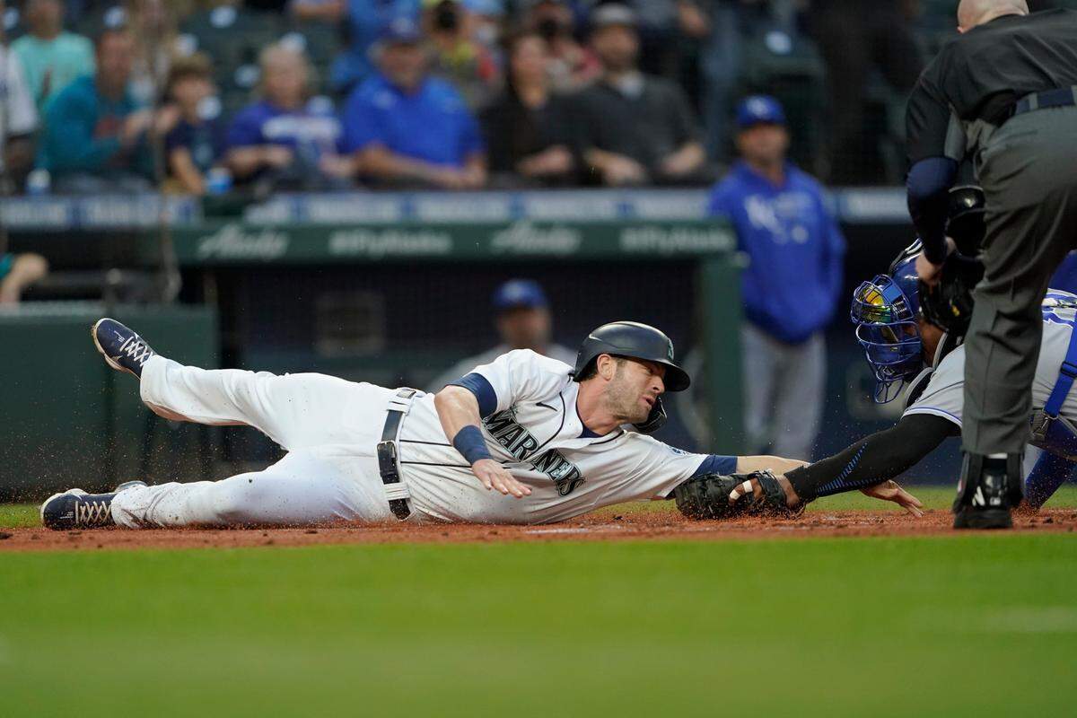 Seattle Mariners’ Mitch Haniger is tagged out at home plate by Kansas City Royals catcher Salvador Perez as Haniger tried to score on a double by Kyle Seager during the first inning of a baseball game, Thursday, Aug. 26, 2021, in Seattle. (AP Photo/Ted S. Warren)