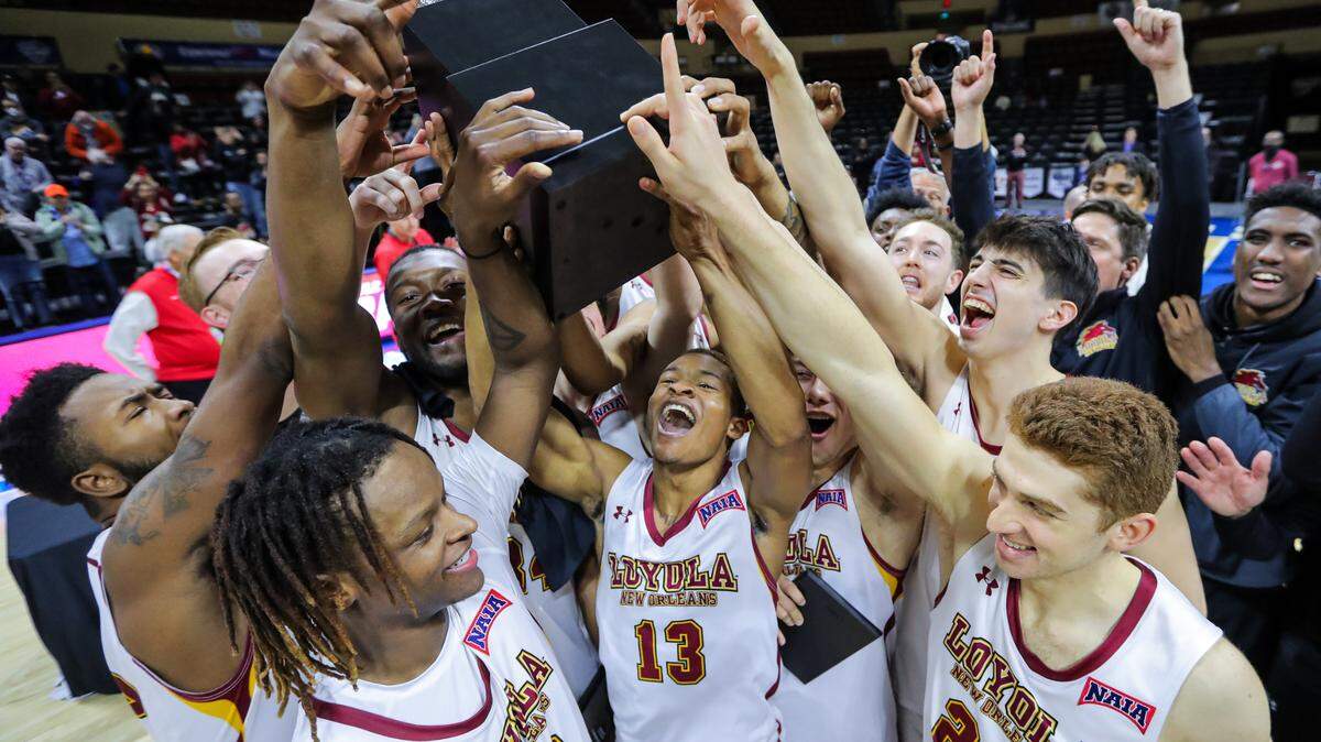 Cameron Dumas, 13, and the Loyola Wolfpack hoist the NAIA championship trophy Tuesday night at Municipal Auditorium after defeating Talladega, 71-56. The title is the Wolfpack’s second NAIA championship.