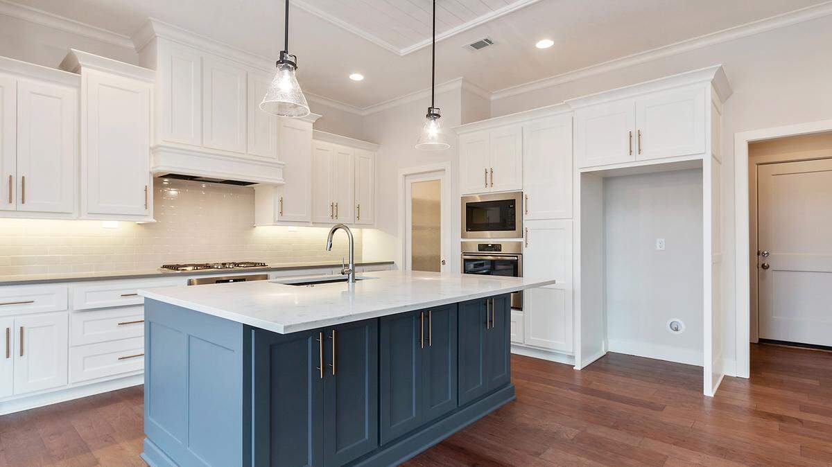 Custom cabinetry and hardwood floors are among the luxurious kitchen finishes offered in Covington Creek’s Alexander reverse story and a half plan.