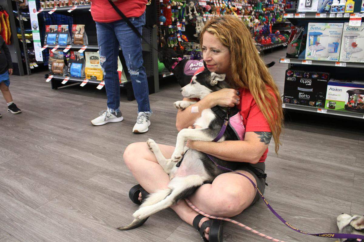 Pawsitive Tails volunteer Kitty Hensley snuggles with Birra, a husky, at an adoption event at Pet Supplies Plus in Leawood.