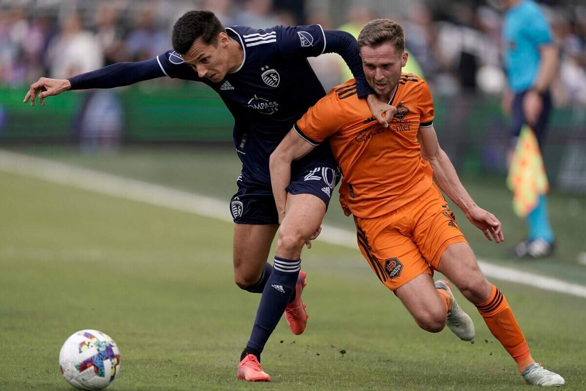 Sporting Kansas City forward Daniel Salloi, left, battles Houston Dynamo defender Adam Lundqvist for the ball at Children’s Mercy Park in Kansas City, Kan.