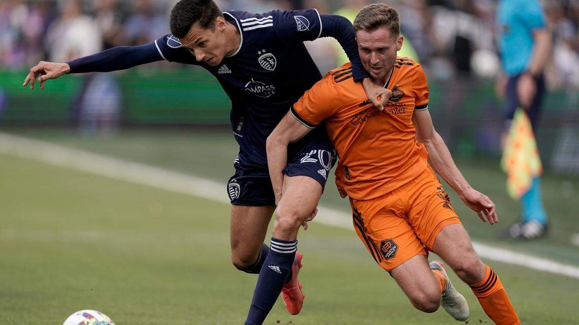 Sporting Kansas City forward Daniel Salloi, left, battles Houston Dynamo defender Adam Lundqvist for the ball during a match at Children’s Mercy Park in Kansas City, Kan.