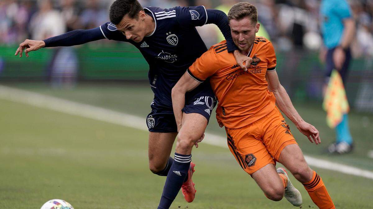 Sporting Kansas City forward Daniel Salloi, left, battles Houston Dynamo defender Adam Lundqvist for the ball on Saturday afternoon at Children’s Mercy Park in Kansas City, Kan.