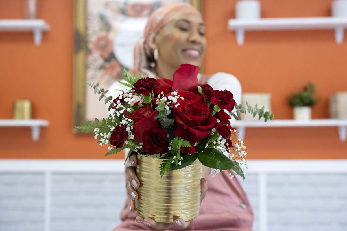 Shahidah Salaam, owner of Pritzy Floral Design Studio, holds out a  floral arrangement for a portrait at her floral studio on Thursday, Jan. 8, 2026, in Grandview.