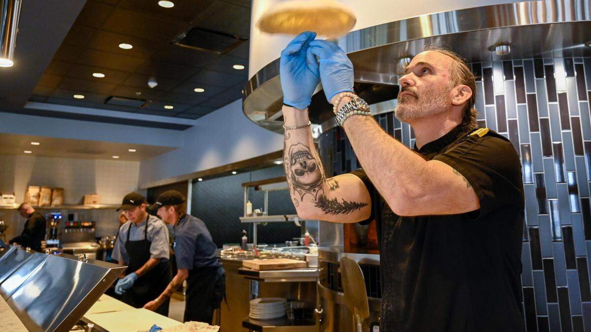 Chef Christian Joseph tosses a pizza crust at Plate in Leawood. Joseph plans to open a pizzeria at Zona Rosa Shopping Center next year.