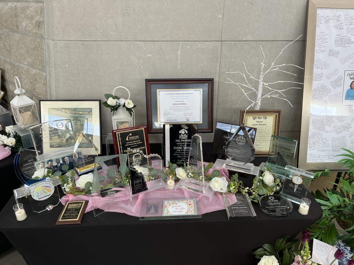 A table displays achievements and awards won by Cynthia Newsome, a longtime KC news anchor, at her funeral on May 30, 2026.