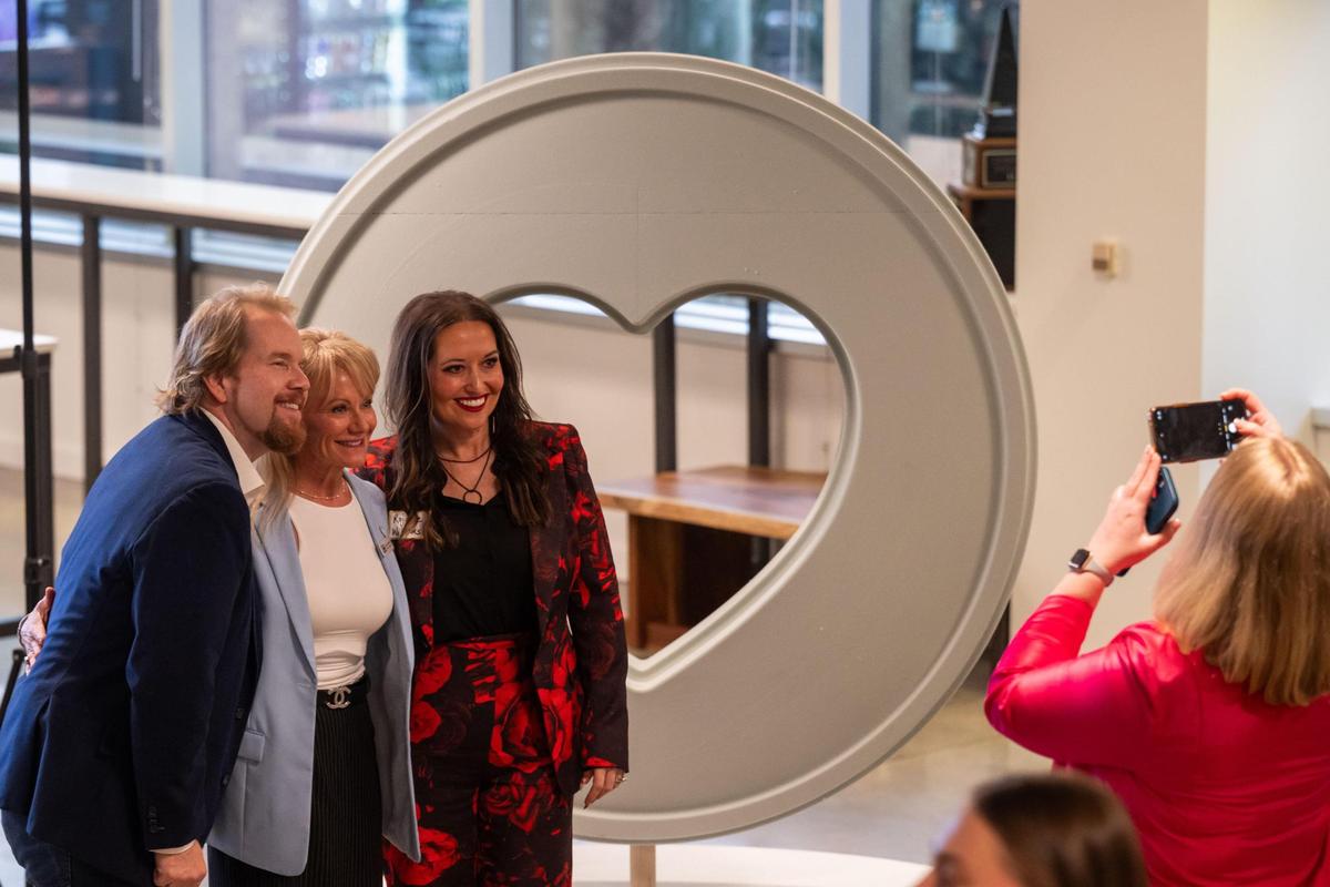 Executive Director of Parade of Hearts, Jenn Nussbeck (c), poses next to the Parade of Hearts redesign on Tuesday, Mar. 4, 2025 in Kansas City. The hearts will be placed in seven counties across the Kansas City region in 2026.