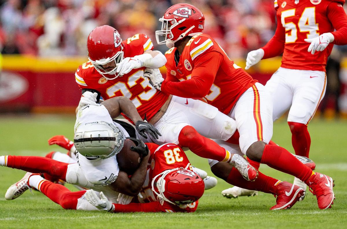 Kansas City Chiefs cornerback L’Jarius Sneed (38) and linebacker Drue Tranquill (23) tackle Las Vegas Raiders running back Zamir White (35) during an NFL football game on Monday, Dec. 25, 2023, at Arrowhead Stadium at GEHA Field in Kansas City.