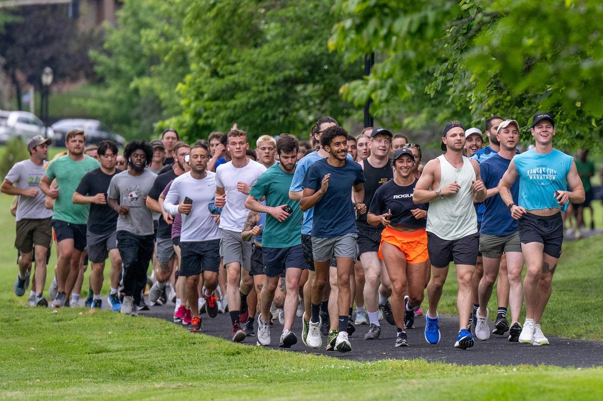 Members of the Kansas Run Club run past Mill Creek Park at a Wednesday evening club meeting.