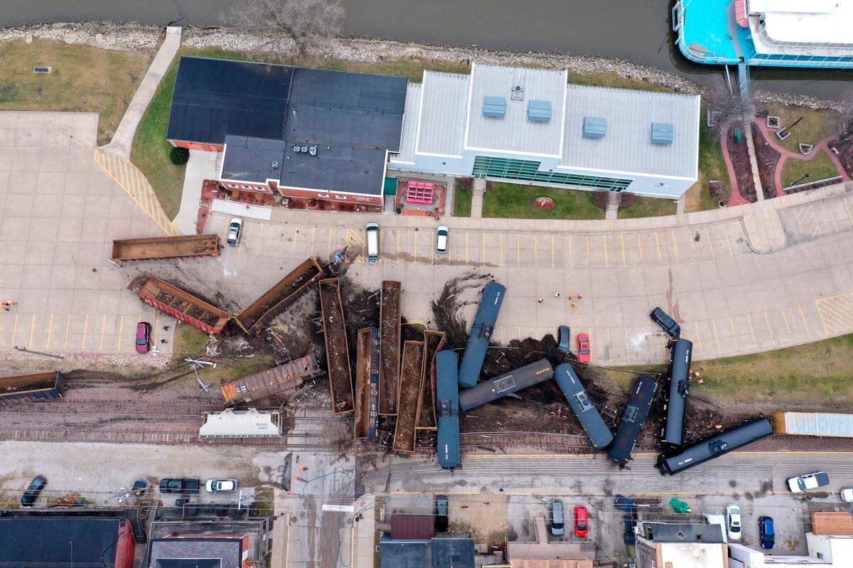 This aerial photo provided by the Scott County, Iowa, Emergency Management Agency shows a train derailment that sent at least a dozen rail cars and tankers off their tracks on Jan. 3, 2020 , in downtown LeClaire, Iowa. The derailment, along U.S. 67, just a couple of hundred feet from the banks of the Mississippi River, forced police to send a hazardous materials team to the site.