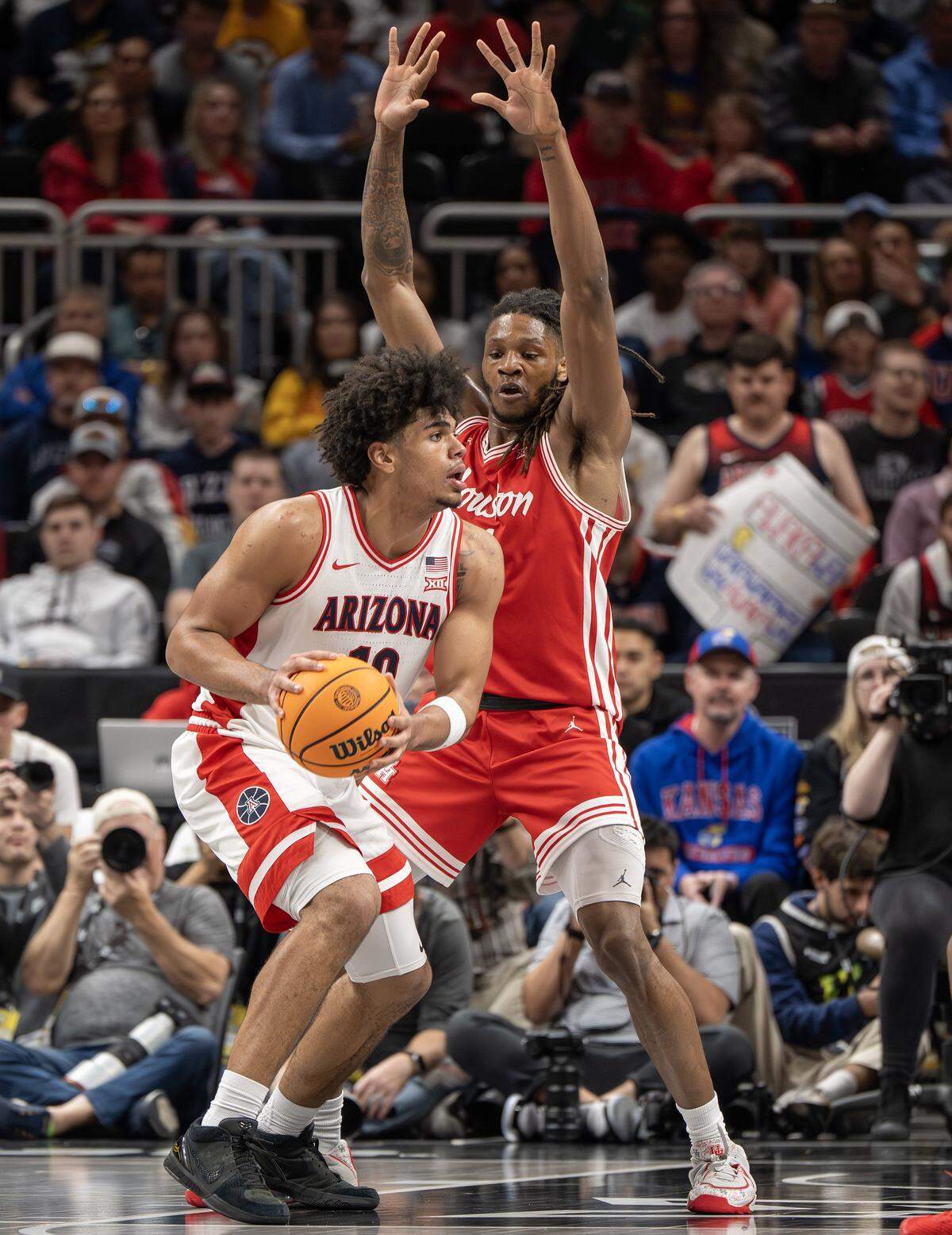 Arizona Wildcats forward Koa Peat (10) shields the ball from Houston Cougars forward Joseph Tugler (11) during the first half of the Big 12 Men's Basketball Tournament Championship game at T-Mobile Center on Saturday, March 14, 2026, in Kansas City.