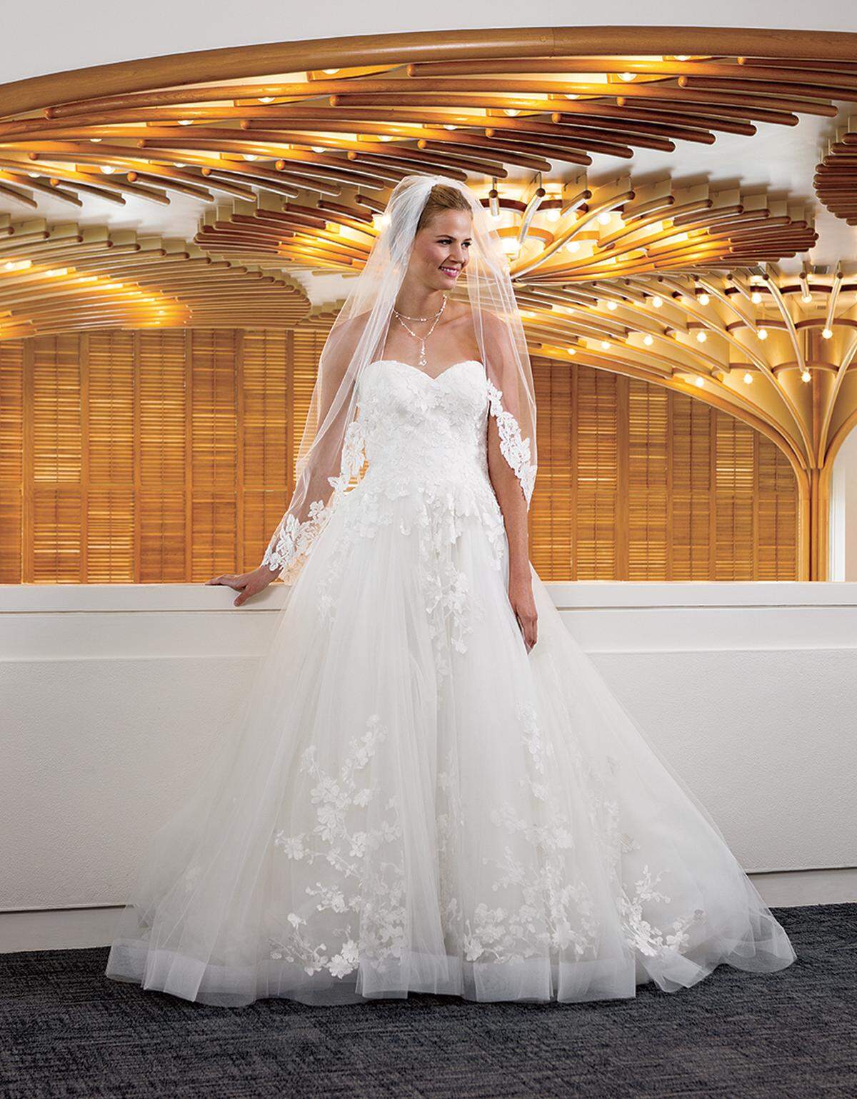 BELLE OF THE BALL “Morning Glory” Casablanca gown with sweetheart neckline and full skirt, $1,425, Bel Aire Bridal lace-trim veil, $300, and Bel Aire Bridal necklace and earrings, $150 as set, all from Wedding Expressions by Geri.