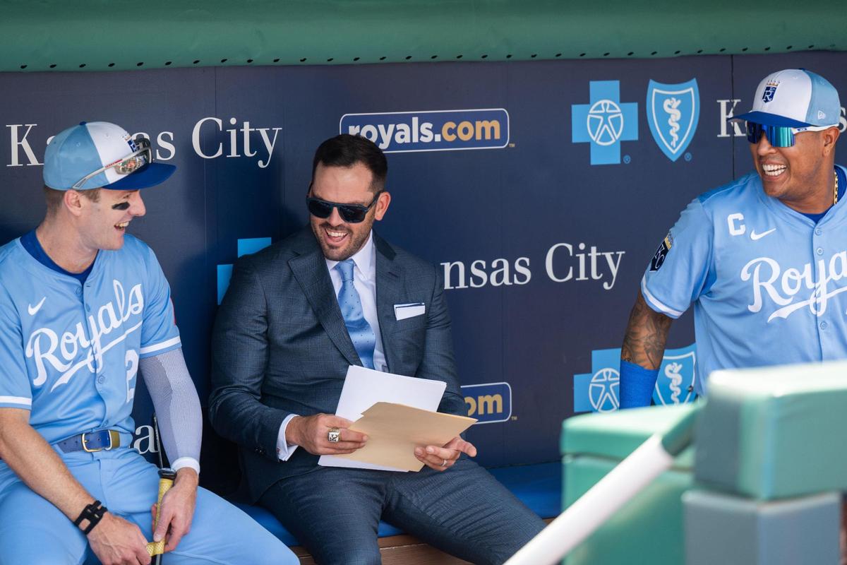 Former Royals great Mike Moustakas shares a laugh in the dugout with former teammate and Royals catcher Salvador Perez and outfielder Mark Canha on Saturday before the game against the Tigers. Moustakas officially retired as a Royal after a 12-year career in Major League Baseball.