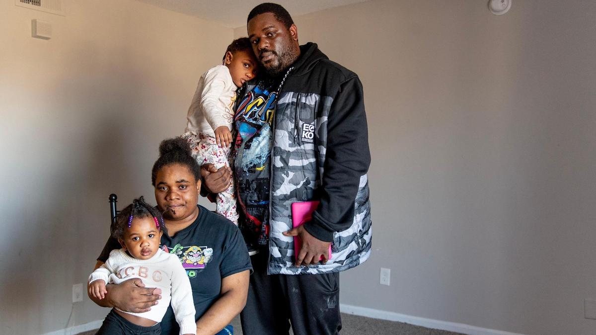 Michele Williams and her fiancé Roosevelt Price pose for a photo with their daughters, Ameerah, 1, and Corrae, 3, in their living room at Stonegate Apartments on Friday in Kansas City. The living room remains void of furniture after water damaged their belongings in a previous unit.
