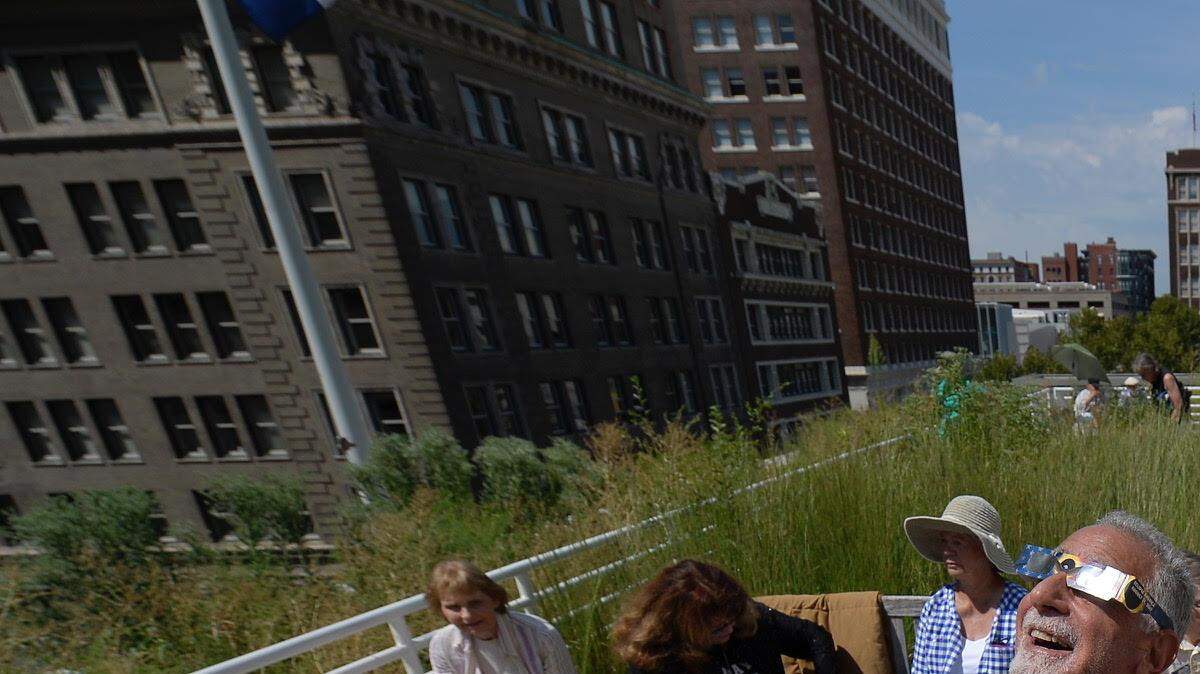 In this 2017 file photo, Lisa Pinsker (from left) of Fairway, Jim Yarmo of Leawood, and Christine Garvey and Pat Garvey of Kansas City got a glimpse of the solar eclipse from the rooftop of the downtown public library.