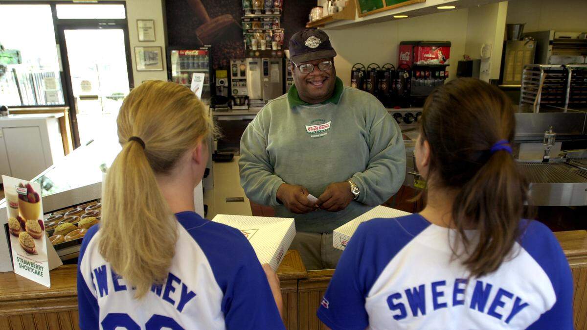 PHOTO BY TAMMY LJUNGBLAD/The Kansas City Star/4-06-04/The promotion is back at Krispy Kreme Doughnuts, so Royals fans and opening day ticket holders Chelsea Carlisle, 17, (left) and Michelle Hinton, 16, both of Liberty, redeemed their ticket stubbs with Krispy Kreme assistant manager Dwayne Rollins (center) on Tuesday for a dozen glazed donuts at the Independence store, 4242 S. Noland Road. When the Kansas City Royals baseball team gets 12 hits, every ticketholder gets a dozen free glazed doughnuts. CUTLINE: The Royals’ thrilling opening-day victory Monday brought excitement to Kansas City and free doughnuts to Chelsea Carlisle, 17, (left) and Michelle Hinton, 16, both of Liberty. They redeemed their ticket stubs with Krispy Kreme assistant manager Dwayne Rollins (center) on Tuesday at the Independence store.