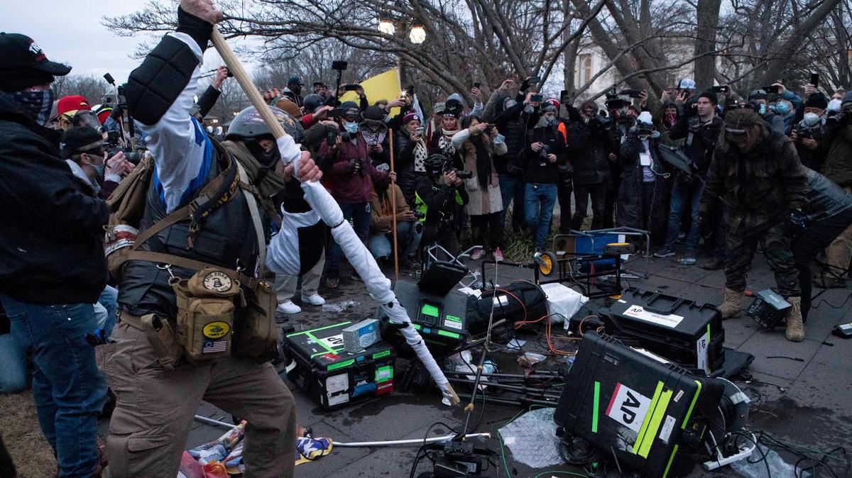 Demonstrators break TV equipment outside the the U.S. Capitol on Wednesday, Jan. 6, 2021, in Washington. (AP Photo/Jose Luis Magana)