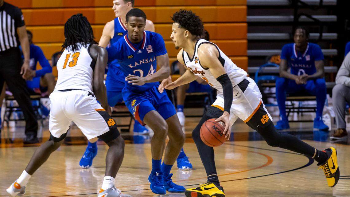 Oklahoma State’s Cade Cunningham dribbles past former Kansas guard Bryce Thompson during the first half of an NCAA college basketball game in Stillwater, Okla., Tuesday, Jan. 12, 2021.