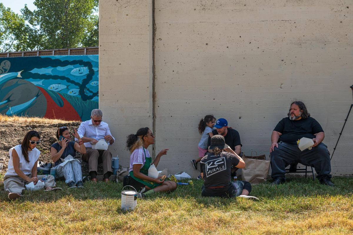 Muralists and event organizers take a lunch break on Friday, Sept. 15, 2023, at the Riverfront Heritage Trail in Kansas City. “This first phase is the message of women, empowerment, and feminism,” Director of Communications for Port KC Meredith Hoenes, said. “I think our artists have done a beautiful job at bringing that to light.”