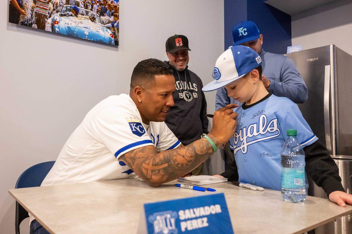 Kansas City Royals catcher Salvador Perez signs the jersey of Maddox Patton during Royals Rally at Kauffman Stadium on Saturday, Jan. 31, 2026.